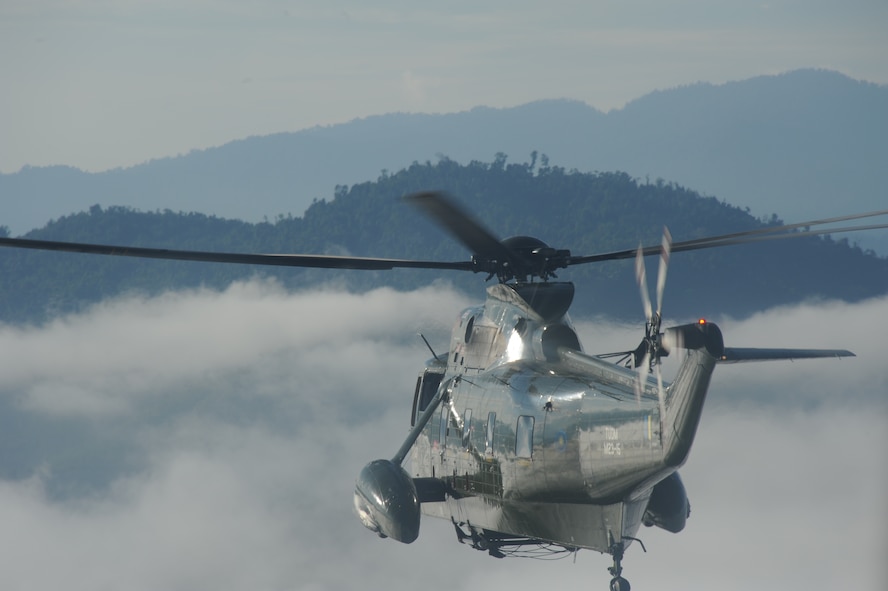 A Royal Malaysian Air Force S-61A-4 Nuri utility helicopter, leads the way through early morning fog during a combat search and rescue exercise as part of Cope Taufan 2012 at TUDM Butterworth, Malaysia, on April 11, 2012. Tech. Sgt. Robert Colliton, 18th Operations Support Squadron Survival, Evasion, Resistance and Escape specialist from Kadena Air Base, Japan, conducted a subject matter expert exchange with RMAF members during the exercise. U.S. Air Force and RMAF airmen also spent time in the jungle of northwest Malaysia refreshing their survival skills. Cope Taufan is a live-flying exercise designed around dissimilar basic fighter maneuvers and dissimilar air combat tactics training. (U.S. Air Force photo/Master Sgt. Matt Summers)