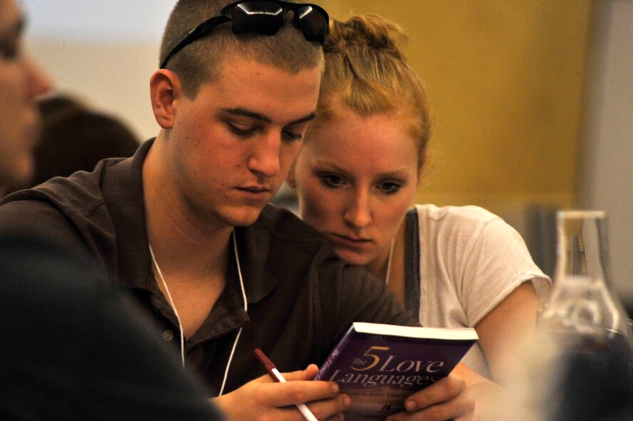 HILTON HEAD, S.C. - Airman 1st Class Corbin Trusdle, an information assurance technician with the 20th Communications Squadron, Shaw AFB, S.C. and his wife Christina read the book, "The Five Love Languages" while attending a marriage retreat at the Crowne Plaza Hotel in Hilton Head, S.C. on March 31, 2012. Trudsdle and his wife joined 19 other couples in attending the three-day marriage care seminar sponsored by the chaplain corps of Shaw Air Force Base, S.C. The retreat provided couples with tools to refine their marriage.  (U.S.  Air Force photo by Master Sgt. Cohen A. Young/Released)