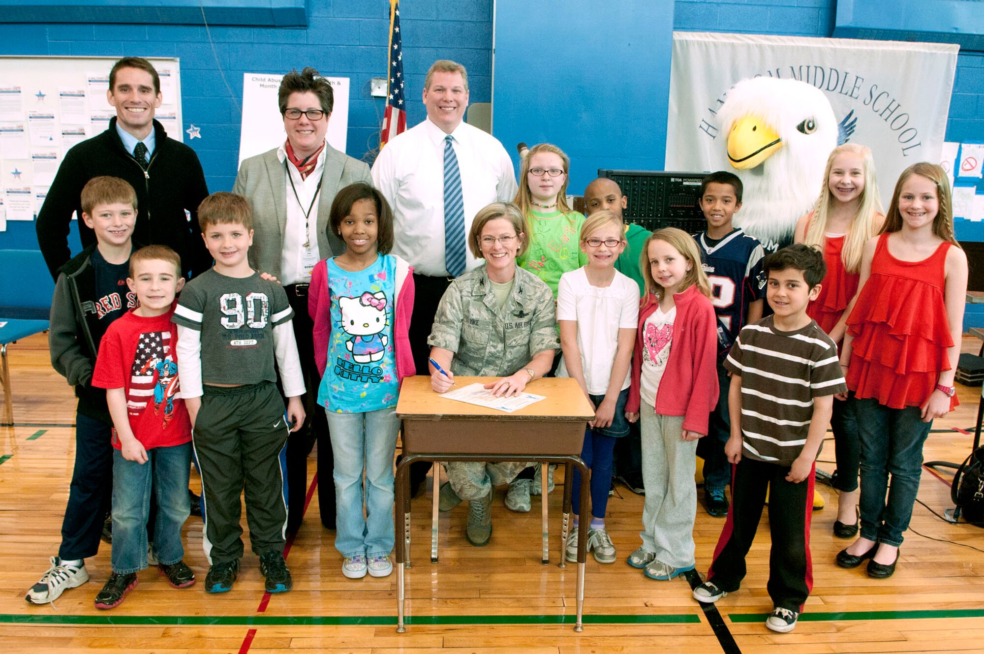 HANSCOM AIR FORCE BASE, Mass. – Col. Stacy L. Yike (center), 66th Air Base Group commander, signs a proclamation declaring April as Child Abuse Prevention Month and Month of the Military Child at Hanscom with (back row, left to right) Matt Nicoli, Family Advocacy Program, Beth Ludwig, Hanscom Primary School principal, and Erich Ledebuhr, Hanscom Middle School principal as well as a host of students from the two schools. Yike signed the proclamation after a short ceremony with music and short speeches by school administrators and staff. (U.S. Air Force photo by Mark Wyatt)