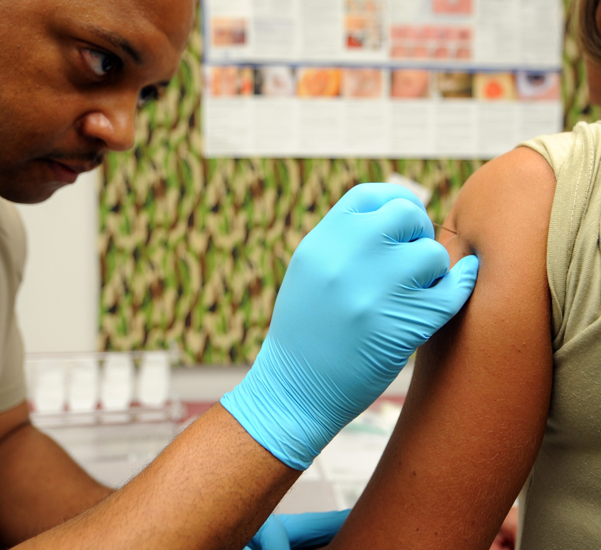 WHITEMAN AIR FORCE BASE, Mo. -- Tech. Sgt. Rennard Greene, 509th Medical Operations Squadron medical technician, keeps a steady hand while delivering a smallpox vaccination April 4 to a deploying Airman. Greene assists in a program designed to train local nursing students on how to deliver proper care to patients. Several local nursing students have had the opportunity to work alongside Airmen in the 509th Medical Group throughout their clinical rotations to get hands-on training with patients. (U.S. Air Force photo/Senior Airman Laura Goodgame)