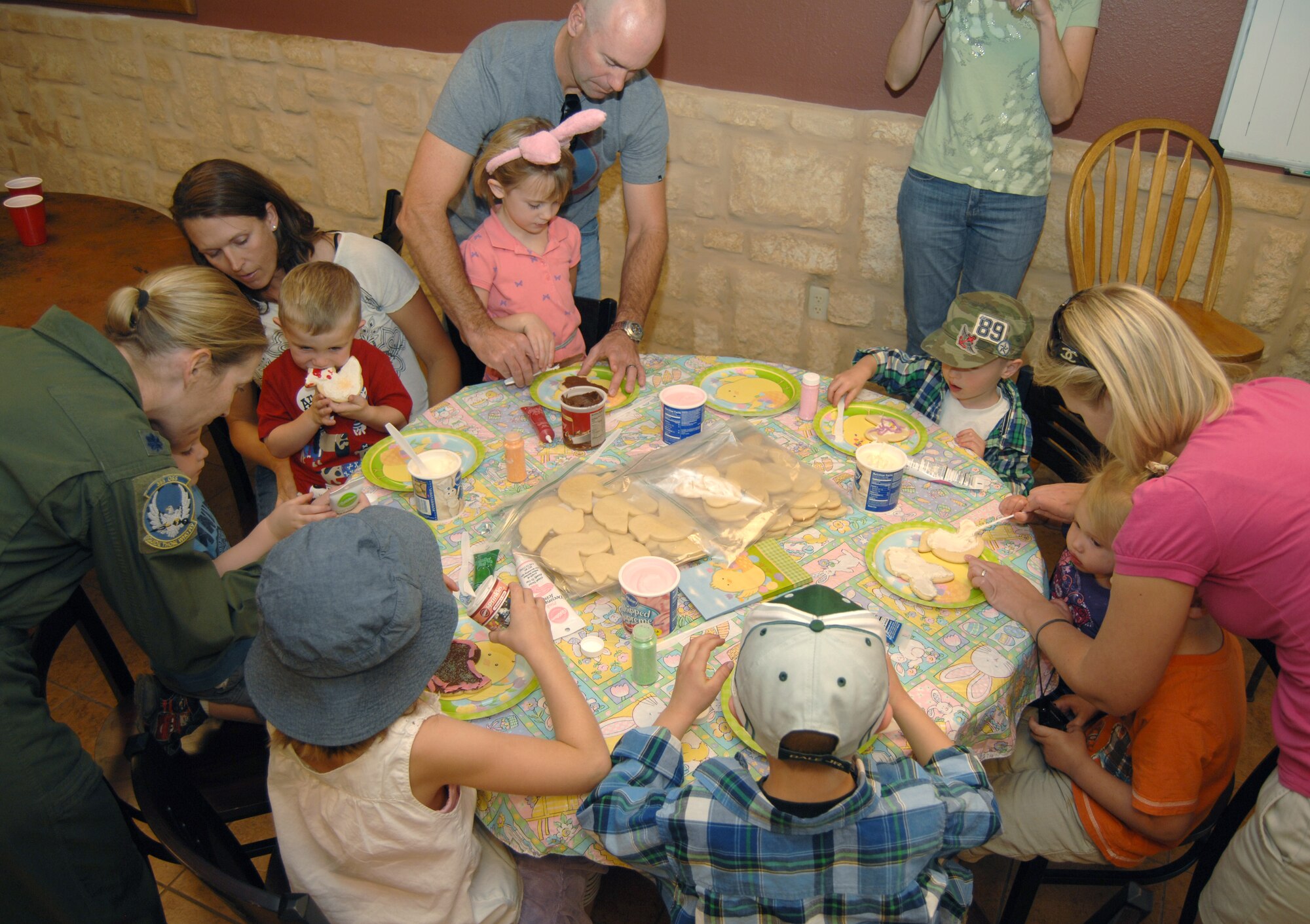 Members of the 358th Fighter Squadron and their children decorate cookies before participating in an Easter egg hunt at Davis-Monthan Air Force Base, Ariz., April 6. More than 60 eggs were hidden for the kids to find. (U.S. Air Force photo by Airman 1st Class Michael Washburn/Released)