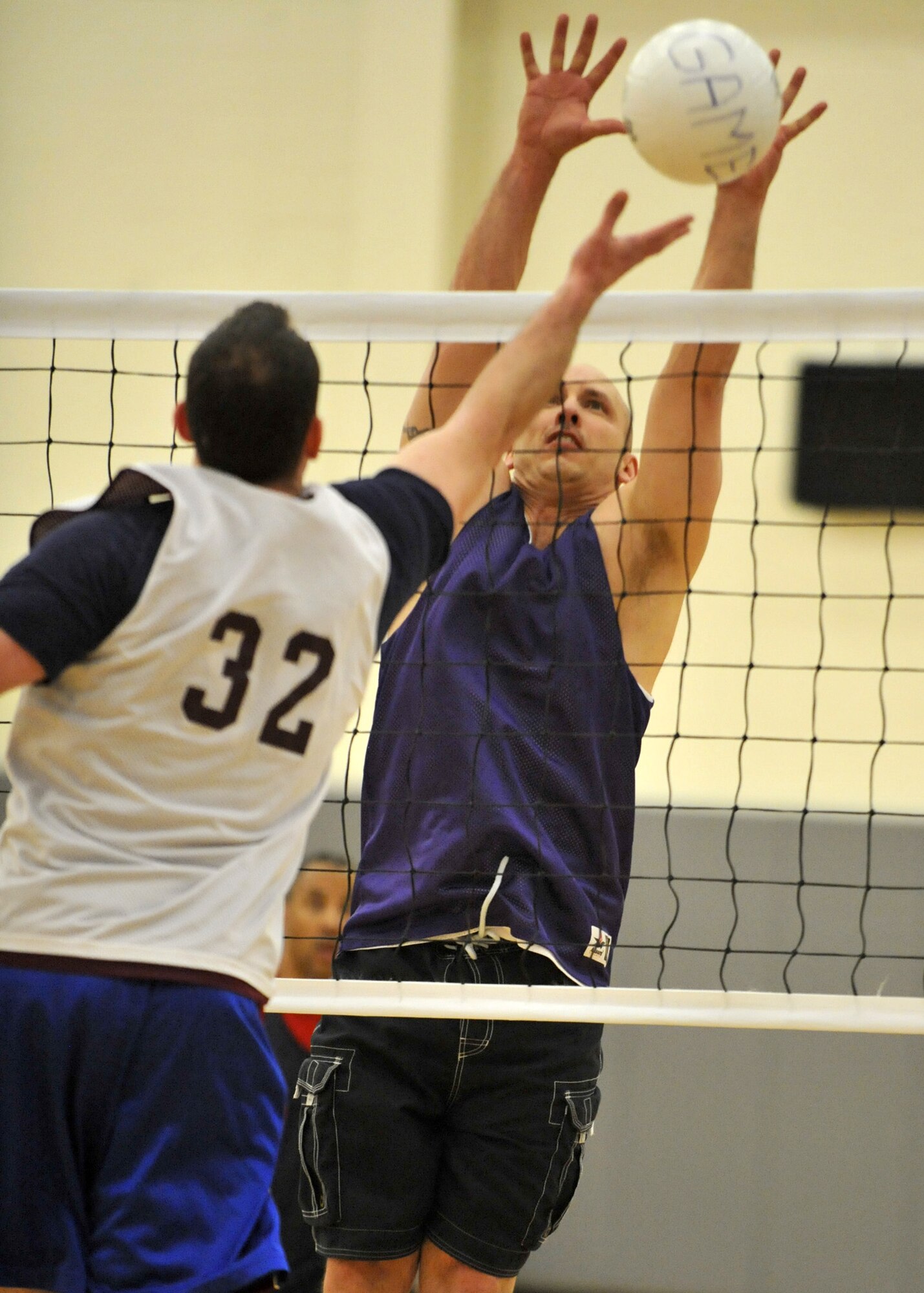 Patrick Piazza of the 436th Aerial Port Squadron A team blocks a shot by Robert Rogers of the 436th Operations Group during an intramural volleyball match at the Base Fitness Center April 10, 2012, on Dover Air Force Base, Del. The 436th APS A team swept the 436th OG 25-13 and 25-19 to remain unbeaten. (U.S. Air Force photo by Tech. Sgt. Chuck Walker)