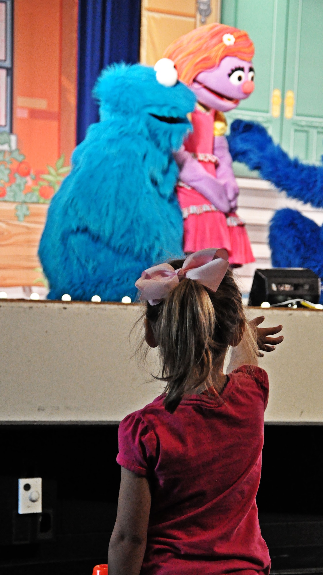 An audience member reaches out hoping to touch the cast of Sesame Street at the base theater at Scott Air Force Base, Ill., April 7, 2012. Katie was created exclusively for the 2012 Sesame Street/USO Experience tour and was first introduced to military families in April 2011 by First Lady Michelle Obama and Dr. Jill Biden at a Joining Forces rally in Columbus, Ohio. (U.S. Air Force photo/Airman 1st Class Jake Eckhardt)