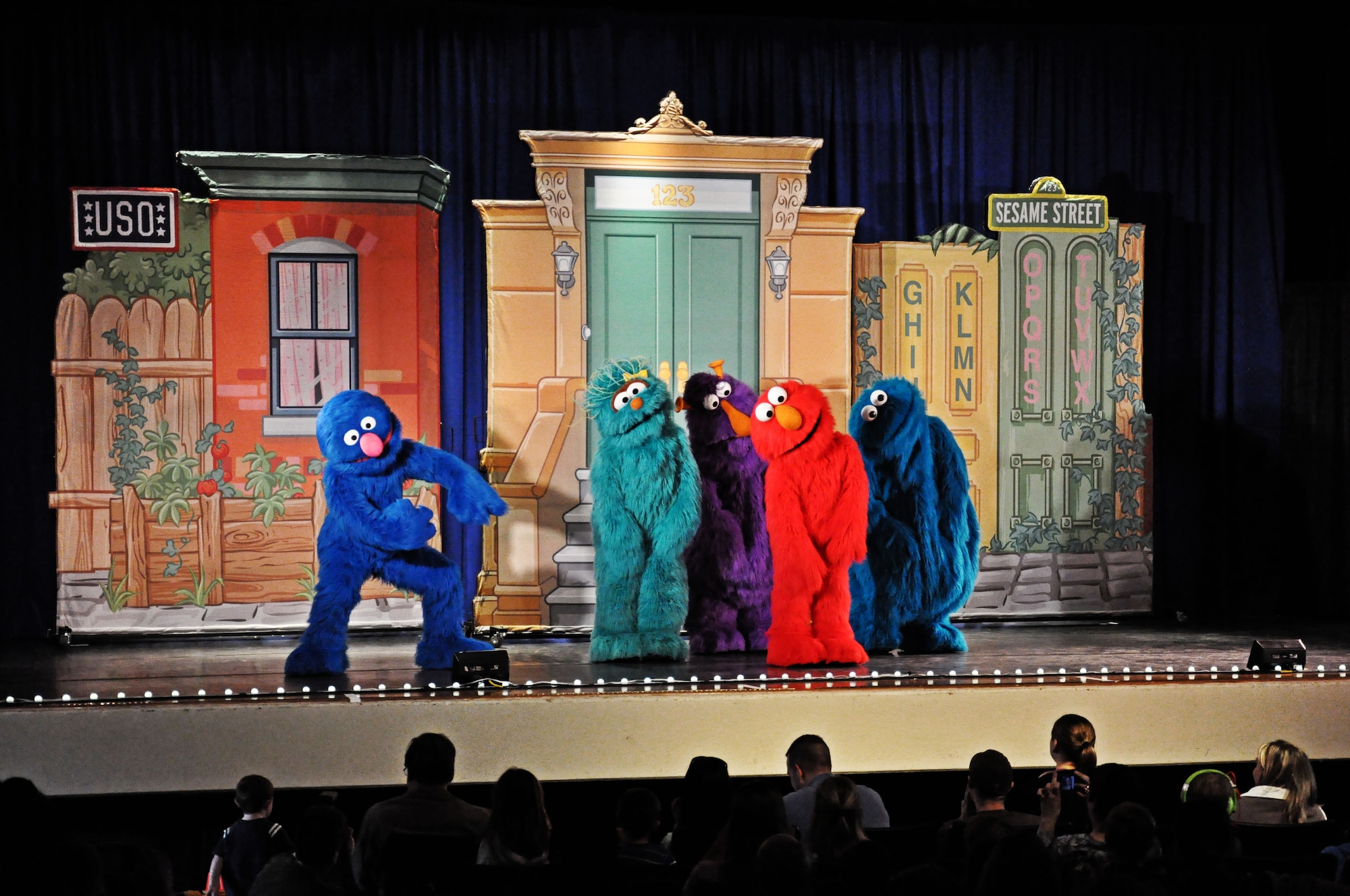 The cast of Sesame Street dance at the base theater at Scott Air Force Base, Ill., April 7, 2012. Scott is the first stop on the 2012 Sesame Street/USO Experience tour out of 70 stops.(U.S. Air Force photo/Airman 1st Class Jake Eckhardt)