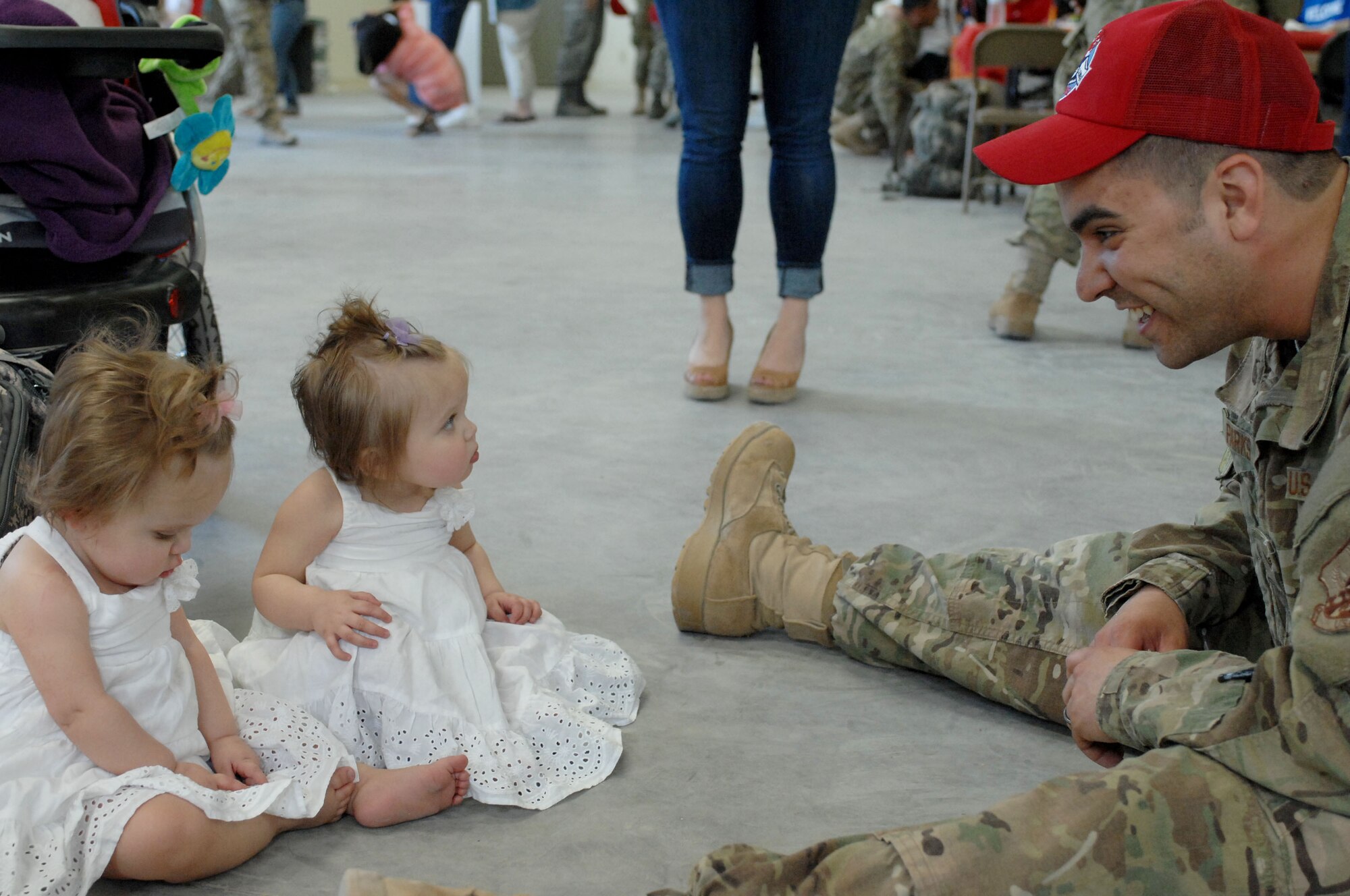 Airman 1st Class Bradley Parks interacts with his daughters Hayden(left) and Payton(right) during a Welcome Home ceremony April 9, 2012 at Nellis Air Force Base, Nev. Parks is a member of the 820th RED HORSE Squadron that returned from a six-month deployment April 9, 2012. (U.S. Air Force photo by Senior Airman Jack Sanders)
