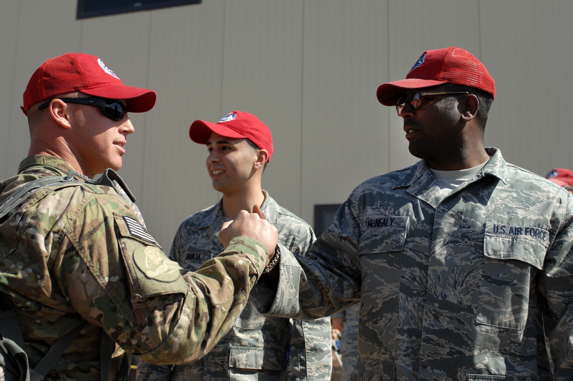 Staff Sgt. Travis McNealy (right) greets fellow 820th RED HORSE Squadron member at a Welcome Home ceremony April 9, 2012 at Nellis Air Force Base, Nev. Families and fellow squadron members lined up to greet returning 820th RHS Airmen. (U.S. Air Force photo by Senior Airman Jack Sanders)