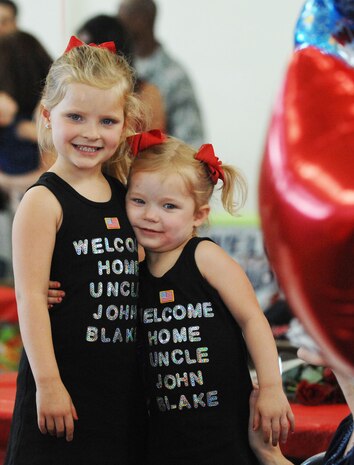 Sister Blythe Peel (left) and Emsley Peel (right) prepare to welcome home their uncle Capt. John Blake Peel, 820th RED HORSE Squadron April 9, 2012 at Nellis Air Force Base, Nev. Squadron and family members of the 820th RHS gathered at a Welcome Home ceremony for deployed 820th RHS member returning. (U.S. Air Force photo by Senior Airman Jack Sanders)