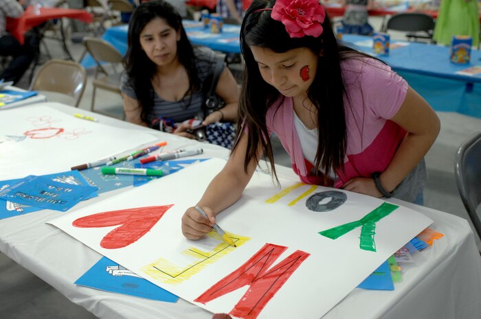 Helen Gonzalez makes a welcome home sign for her brother Senior Airman Andres Gonzales before he returns from a deployment April 9, 2012 at Nellis Air Force Base, Nev. Gonzales is assigned to the 820th RED HORSE Squadron stationed here. (U.S. Air Force photo by Senior Airman Jack Sanders)