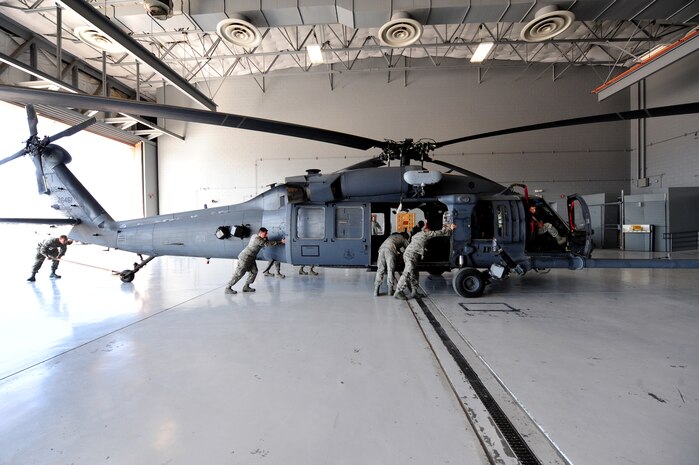 Airmen from the 763rd Maintenance Squadron, push a HH-60 Pave Hawk helicopter into a hanger April 6, 2012 at Nellis Air Force Base, Nev.  The 763rd MXS must keep helicopters out of inclement winds to avoid serious damage.  (U.S. Air Force photo by Staff Sgt. William P.Coleman)  