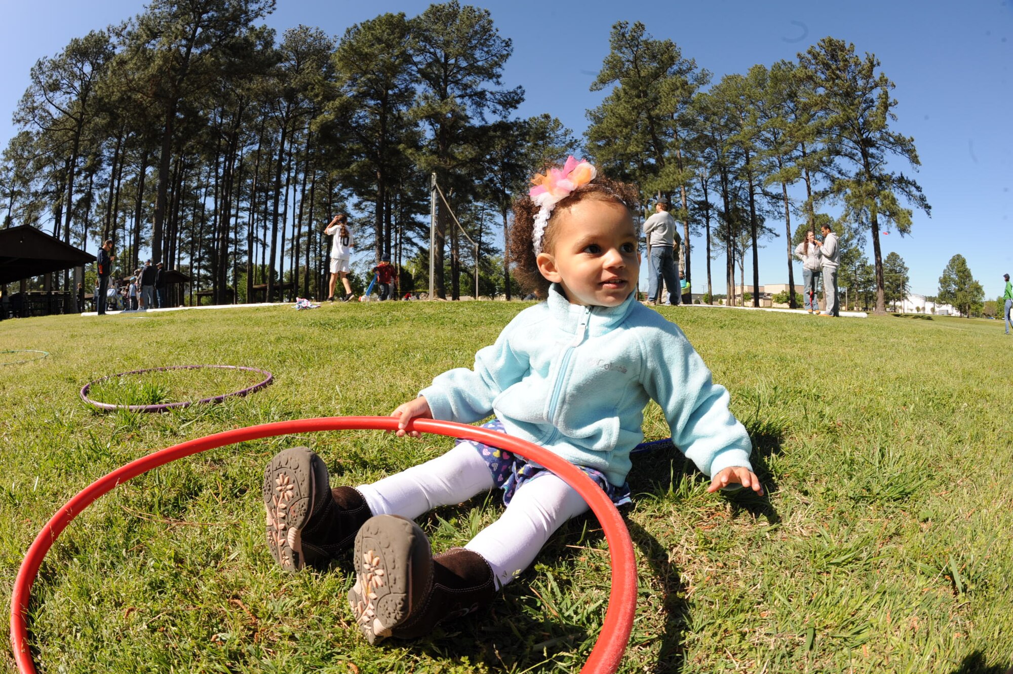 Amelia Lynch, 2, plays with a hula-hoop at Debden Park on Seymour Johnson Air Force Base, N.C., April 7, 2012. Members of the 4th Force Support Squadron coordinated several games and activities for children to enjoy during the base Easter Egg Hunt. Amelia is the daughter of Senior Airman Charles Lynch, 4th Aircraft Maintenance Squadron avionics specialist, and hails from Suisun City, Calif. (U.S. Air Force photo/Airman 1st Class Aubrey Robinson/Released)