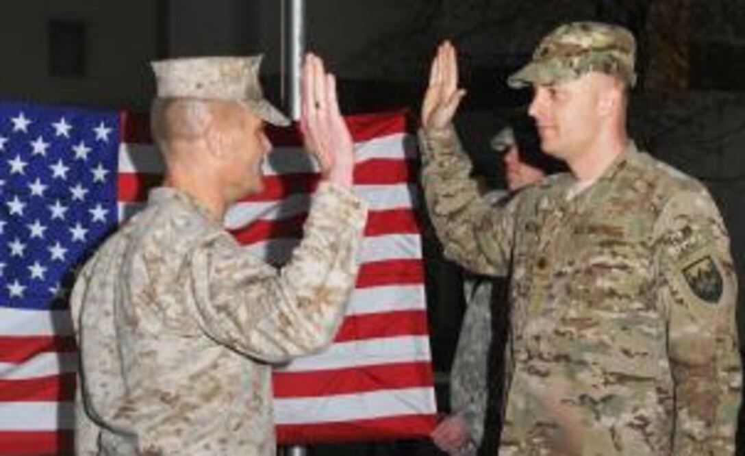 Maj. Mark Melin, right, renews his commissioning oath at a ceremony marking his promotion to major in Kabul, Afghanistan, April 1, 2012. (U.S. Army photo by Sgt. 1st Class Mark Porter)  
