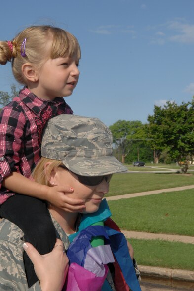 Tech. Sgt. Pamela Bradford, 2nd Maintenance Operations Squadron,  and daughter Victoria, 4, participate in a parade on Barksdale Air Force Base, La., April 5. The parade was held in support of the National Month of the Military Child. This special celebration is a legacy of former Defense Secretary Caspar Weinberger and was established to underscore the important role children play in the armed forces community. (U.S. Air Force photo/Airman 1st Class Joseph A. Pagán Jr.)(RELEASED)

