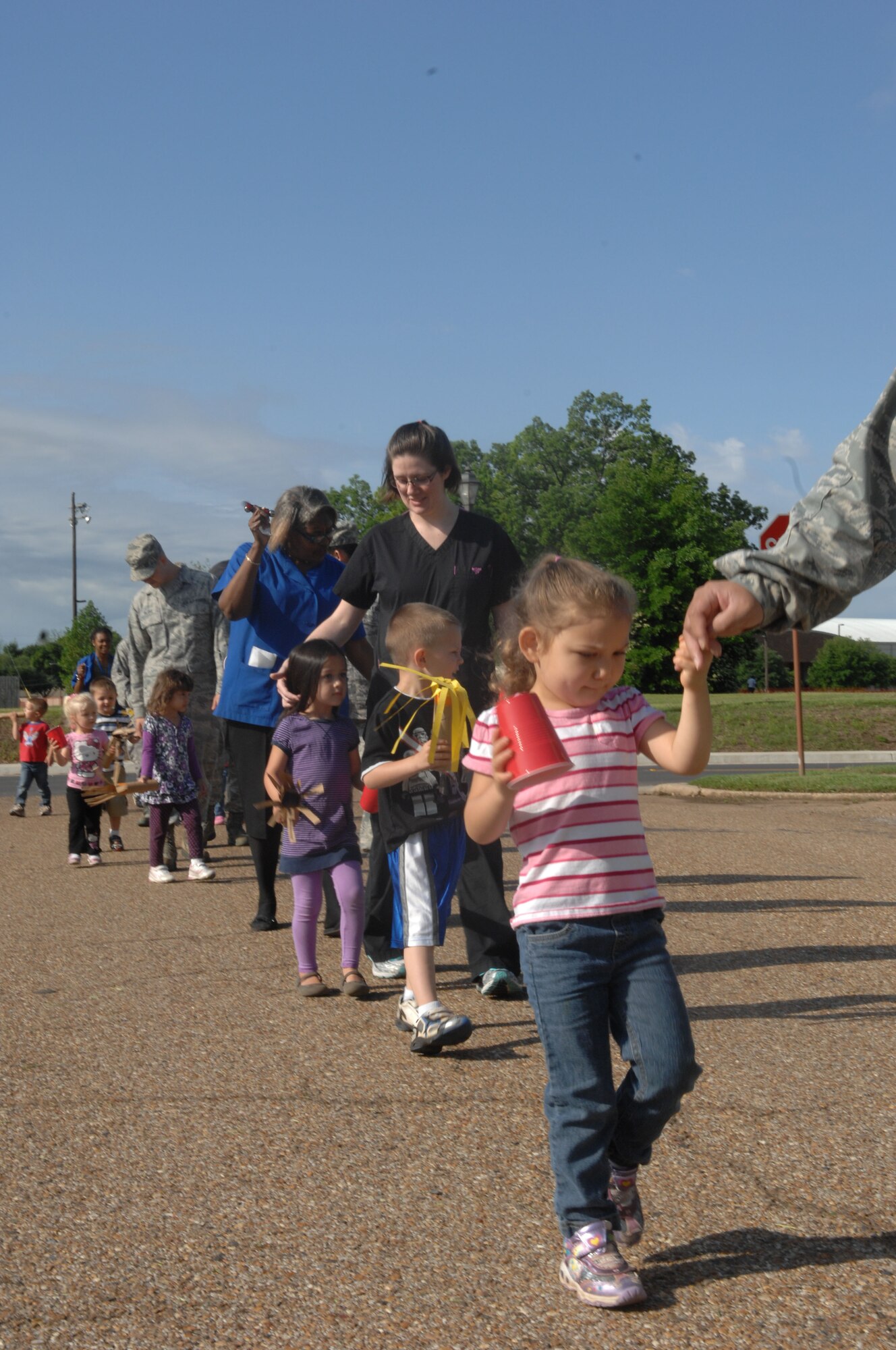 Parents join their children and Child Development Center providers for a parade around Barksdale Air Force Base, La., April 5. The parade was held in support of the National Month of the Military Child. The children had fun singing and playing with their parents and providers as a fire truck led the way. (U.S. Air Force photo/Airman 1st Class Joseph A. Pagán Jr.)(RELEASED)