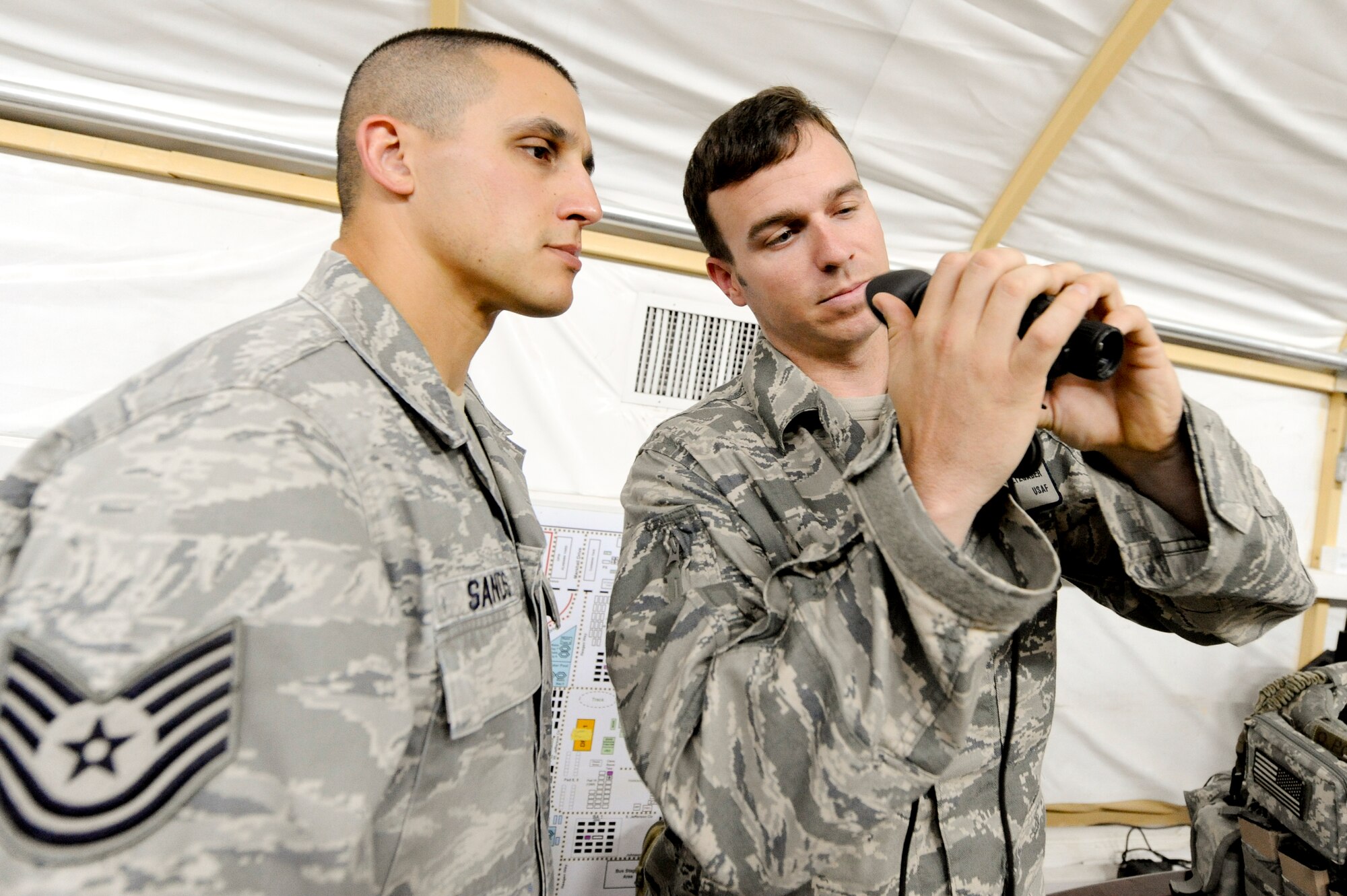 CAMP BUEHRING, KUWAIT -- Tech. Sgt. Timothy Sands, 332nd Air Expeditionary Wing ground safety NCO, is briefed by Senior Airman Ryan Saltzgaber, 82nd Expeditionary Air Support Squadron radio operator maintainer and driver, on the functions of a thermal monocular goggle here, April 10, 2012. The 82nd EASOS is assigned to a Army combat unit, and advises ground commanders on the best use of air power. Sands is deployed from Kirtland Air Force Base, N.M. and is a native of Albuquerque, N.M. Saltzgaber is deployed from Ft. Hood, Texas, and is a native of Abilene, Texas. (U.S. Air Force photo by Staff Sgt. Joshua J. Garcia)
