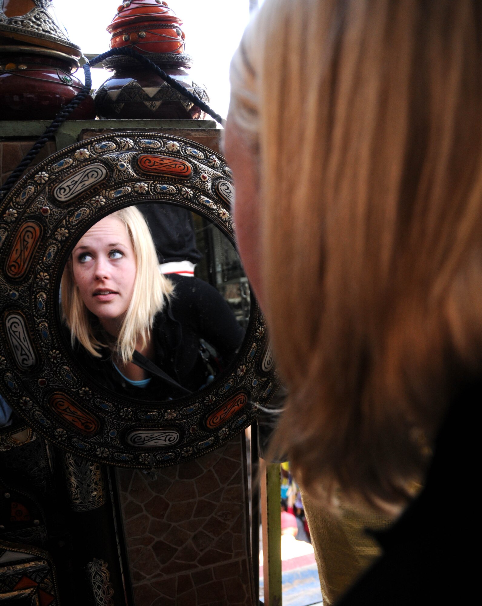 MOROCCO, Marakech -- U.S. Army Sgt. Abigail Waldrop, U.S. Air Forces Africa American Forces Network, looks at decorative mirrors at the Jemaa el Fna market here April 2. Waldrop visited the market with a group of service members as part of a culture exploration day before supporting the Marrakech Aeroexpo 2012. U.S. Air Forces Africa participated in the third biennial Aeroexpo Marrekech to strengthen the partnerships with the nations involved and show commitment to security and stability in the region. This group of service members looked out for one another on their trip to the market ensuring no one was lost, left behind or injured. (U.S. Air Force photo by Senior Airman Natasha Stannard/Released)

