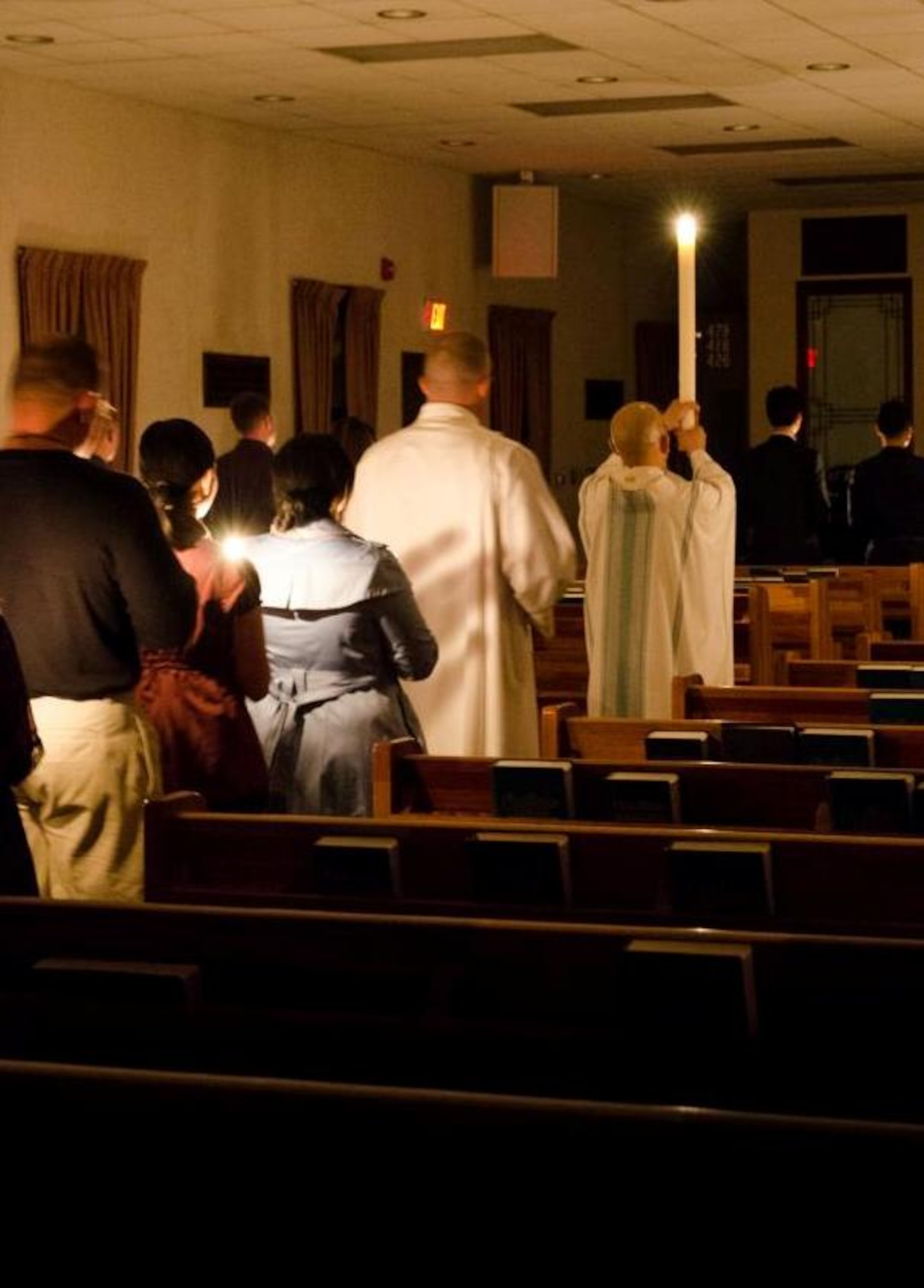Parishioners processed into the darkened chapel from outside, where the Paschal candle was lit during the Catholic Easter Vigil Mass, April 7, 2012, at Kunsan Air Base, Republic of Korea. In many religions, the Paschal candle serves as a symbol of faith for believers in Jesus Christ. (U.S. Air Force photo/Senior Airman Derrick Schwieters)