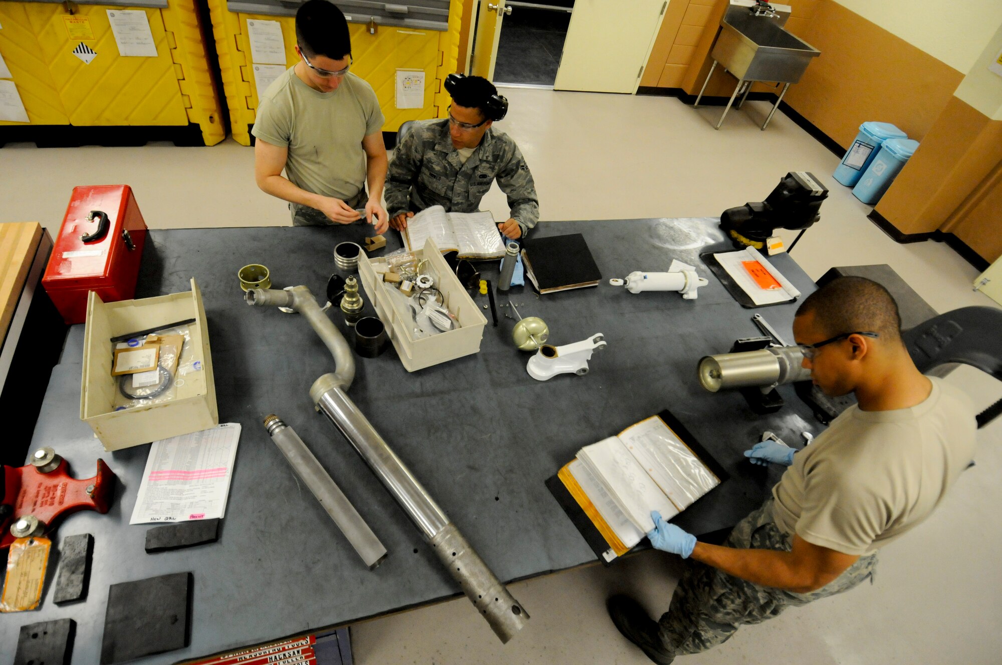 U.S. Air Force Senior Airman Matthew Foos, Airmen 1st Class James Ruggiero and Andrew Howes, 18th Component Maintenance Squadron hydraulic aircraft systems technicians, perform scheduled maintenance on a jet fuel starter on Kadena Air Base, Japan, April 5, 2012. Servicing hydraulic systems for aircraft and force security is an everyday job for the technicians of the 18th CMS. (U.S. Air Force photo by Airman 1st Class Tara A. Williamson/Released)