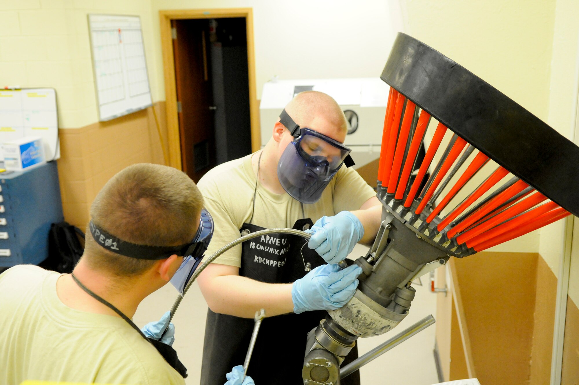 U.S. Air Force Airman 1st Class William Vinson and Senior Airman Stephen Geary, 18th Component Maintenance Squadron hydraulic aircraft systems journeymen, test an aerial refueling drogue from a U.S. Air Force KC-135 Stratotanker refueling aircraft on Kadena Air Base, Japan, April 5, 2012. The refueling drogues require a test every 180 days to ensure they are in proper working order. (U.S. Air Force photo by Airman 1st Class Tara A. Williamson/Released)