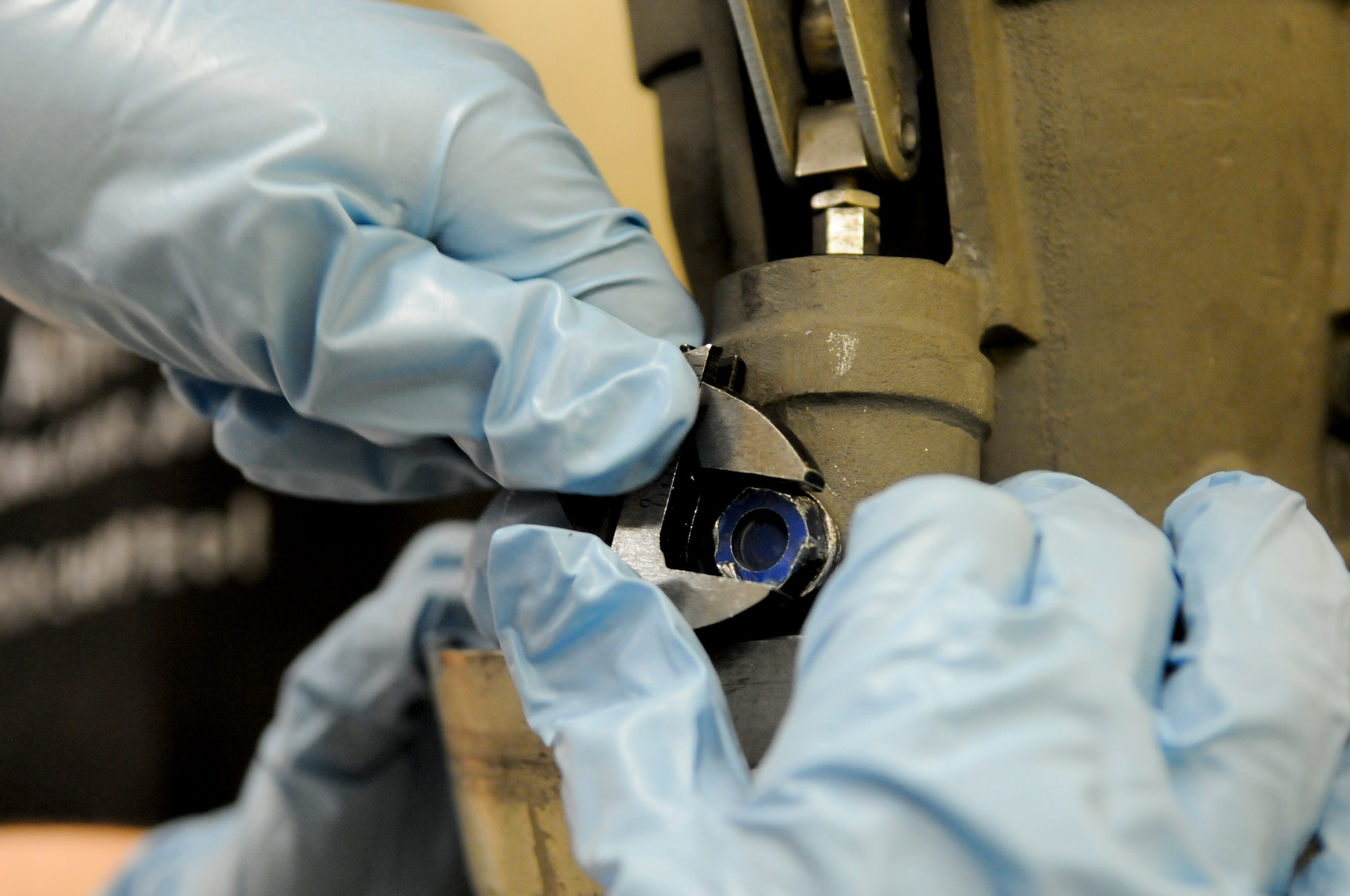 U.S. Air Force Senior Airman Stephen Geary, 18th Component Maintenance Squadron hydraulic aircraft systems journeyman, makes sure to get a tight grip with a wrench before loosening a bolt during a test on an aerial refueling drogue from a U.S. Air Force KC-135 Stratotanker refueling aircraft on Kadena Air Base, Japan, April 5, 2012. The refueling drogues require an inspection every 180 days to ensure they are in proper working order. (U.S. Air Force photo by Airman 1st Class Tara A. Williamson/Released)