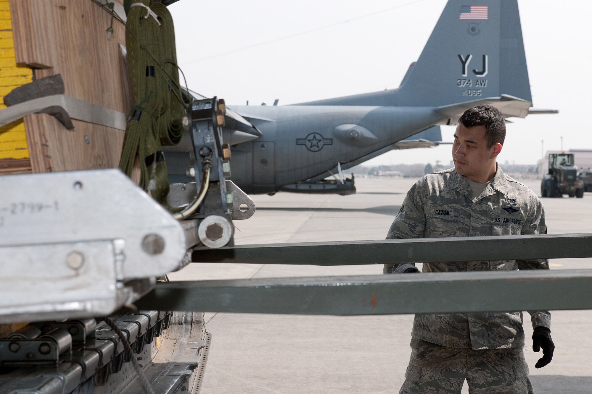 YOKOTA AIR BASE, Japan -- Airman 1st Class Adam Caton, 374th Logistics Readiness Squadron air transportation specialist, visually conforms the safety loading container delivery bundles onto a C-130 Hercules at Yokota Air Base, Japan, April 10, 2012. Airmen from the 374th LRS maintains and provides aerial equipments for use during training exercise and real-world deployment. (U.S. Air Force photo/Osakabe Yasuo)