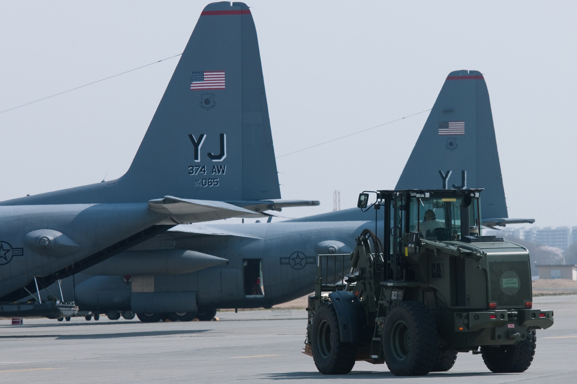 YOKOTA AIR BASE, Japan -- Member from the 374th Logistics Readiness Squadron combat mobility flight drives a 10K forklift on the flightline to loading container delivery bundles onto a C-130 Hercules at Yokota Air Base, Japan, April 10, 2012. Airmen from the 374th LRS maintains and provides aerial equipments for use during training exercise and real-world deployment. (U.S. Air Force photo/Osakabe Yasuo)
