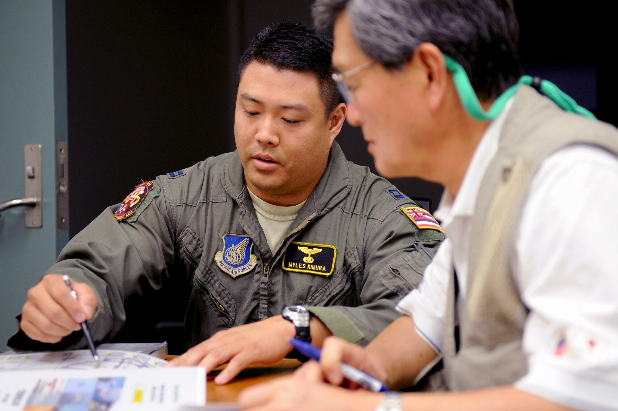 Susuma Tokunaga, reporter with Aireview Magazine (Japan) reviews flight plans with Capt.  Myles Kimura, a KC-135 pilot with the 203rd Air Refueling Squadron on Joint Base Pearl Harbor-Hickam, HI, March 2. Tokunaga is documenting the 15th Wing, as part of the Pacific Air Forces, for a special edition of Aireview Magazine which focuses on the PACAF mission, as well as the relief that the 15th Wing provided during Operation Tomodachi.  (U.S. Air Force photo/Staff Sgt. Mike Meares)