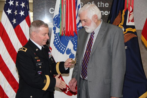 WASHINGTON — Maj. Gen. Merdith Temple, acting chief of engineers of the U.S. Army Corps of Engineers, presents a Corps Castle to Leland Johnson, author of "Situation Desperate: U.S. Army Corps of Engineers Disaster Relief Operations, Origins to 1950". Johnson is a freelance writer and researcher from Westmoreland, Tenn. The Office of History officially published the book in a ceremony at the U.S. Army Corps of Engineers Headquarters, Mar. 23, 2012.