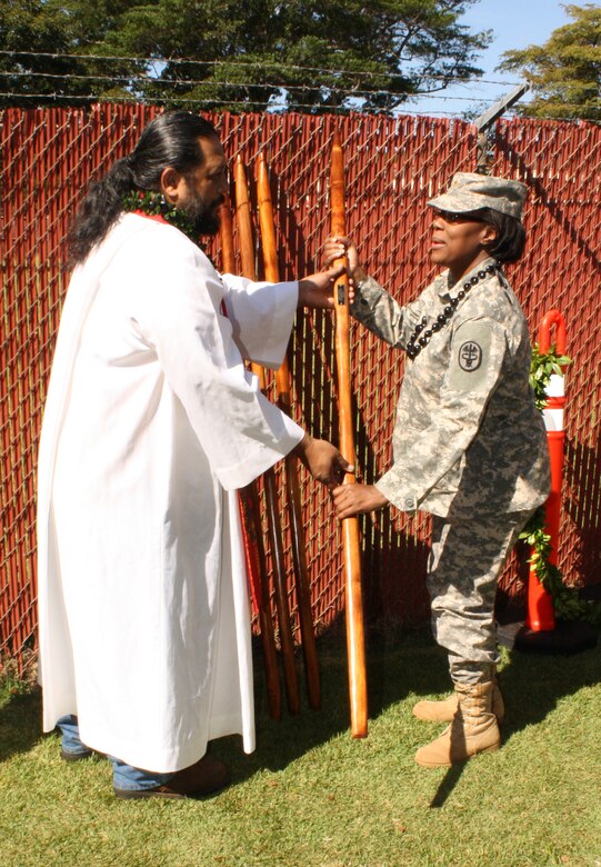 Warrior Transition Battalion Deputy Commander Maj. Stephanie Garvin accepts a Hawaiian `O'o stick from the Kapu during a traditional Hawaiian site blessing ceremony for a new $59.085 million Warriors in Transition barracks and complex.