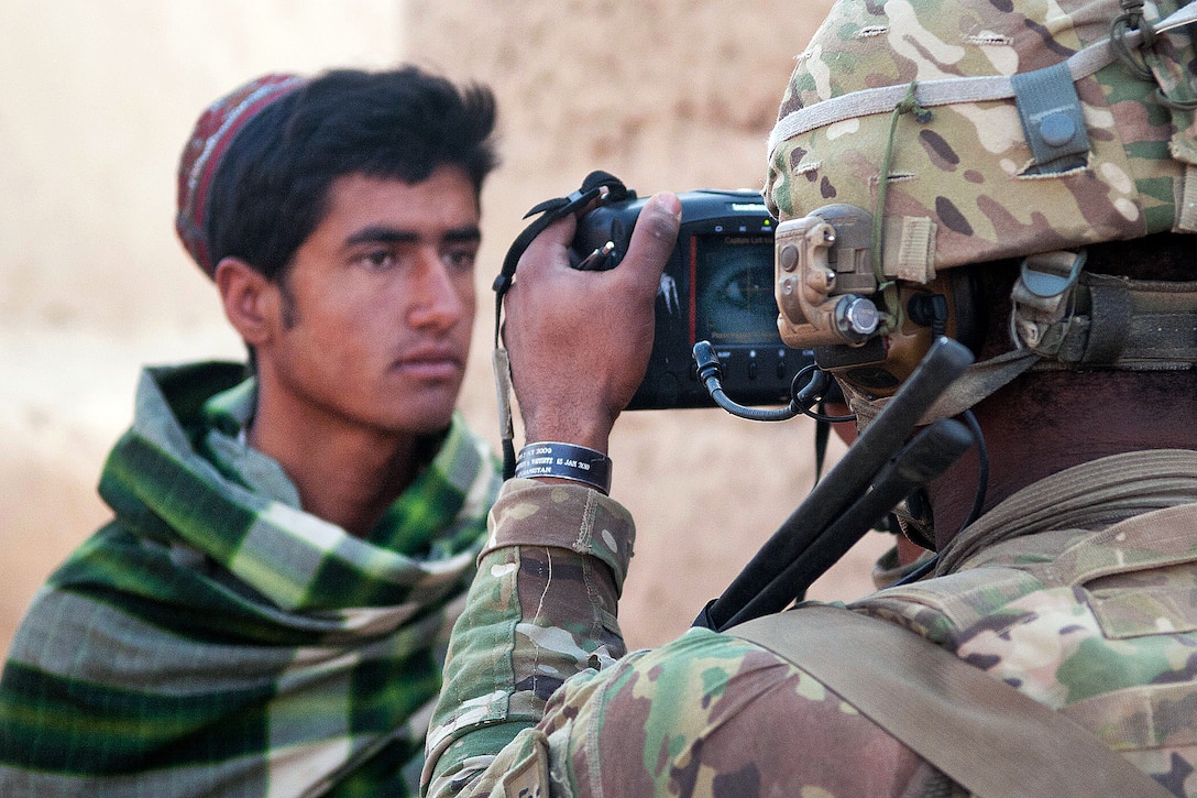 U.S. Army Sgt. Kevon Campbell uses a Handheld Interagency Identity Detection Equipment, or HIIDE, system to check the identity of an Afghan villager against a database of known insurgents during a search of a compound in southern Ghazni province, Afghanistan, April 8, 2012. Campbell is a combat medic assigned to the 82nd Airborne Division’s 1st Brigade Combat Team. The equipment stores an image of the person’s iris as well as his fingerprints.
