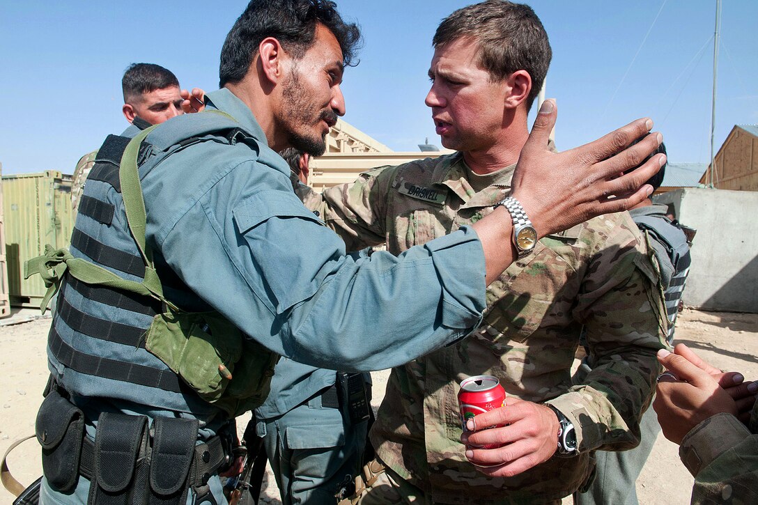 U.S. Army Capt. Joseph Driskell, right, hugs an Afghan policeman on Forward Operating Base Warrior  following a partnered operation to find a suspected weapons in southern Ghazni province, Afghanistan, April 8, 2012. Driskell, a infantry company commander, is assigned to the 82nd Airborne Division’s 1st Brigade Combat Team.
