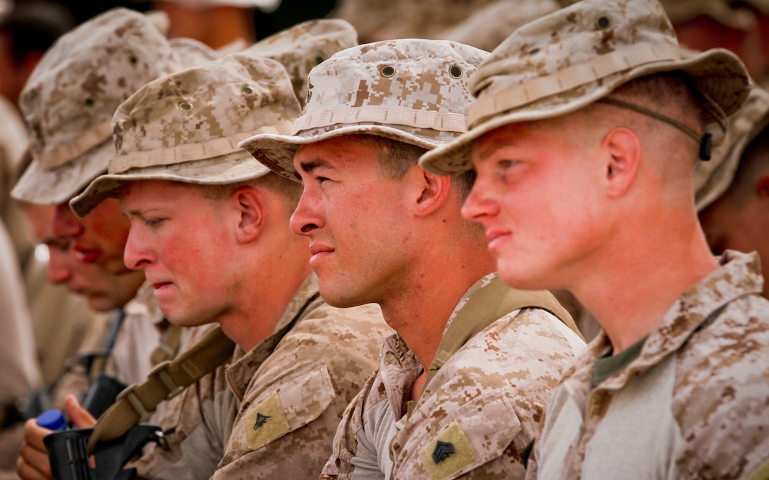(From left) U.S. Marines Lance Cpl. Randall Paul, Sgt. Gregory Hartman, and 1st Lt. Alexander White, Marines serving with White Platoon, 1st Light Armored Reconnaissance Battalion, listen while a Marine recalls a funny anecdote about Cpl. Roberto Cazarez, during a memorial service held in his honor April 8, 2012. Cazarez, a light armored vehicle driver and an Angostura, Mexico, native, was killed in action during combat operations March 30, 2012. He enlisted in the Marine Corps out of Los Angeles, served for nearly six years and was with the battalion since March 2010. Paul is a New Palestine, Ind., native, Hartman is a Sacramento native, and White is a Fredericksburg, Va., native.