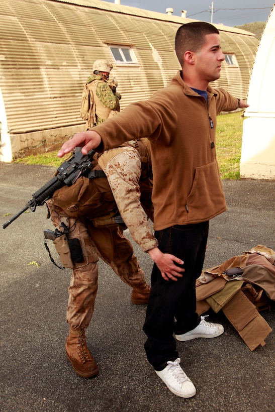 Lance Cpl. Matthew J. French, military police, Military Police Detachment, Combat Logistics Battalion 15, 15th Marine Expeditionary Unit, searches Lance Cpl. Rafael Montalvo, a role player acting as an American citizen, for dangerous items during a non-combatant evacuation operation training, here, April 11. The NEO was the final training evolution during MEU Exercise, held April 2-12, to train the major subordinate elements of the 15th MEU to operate as a Marine Air Ground Task Force. Montalvo, 22, is a native of Yorkville, Ill., and serves as an asset manager with Marine Medium Helicopter Squadron 364, 15th MEU. French, 20, is a native of Antioch, Ill.