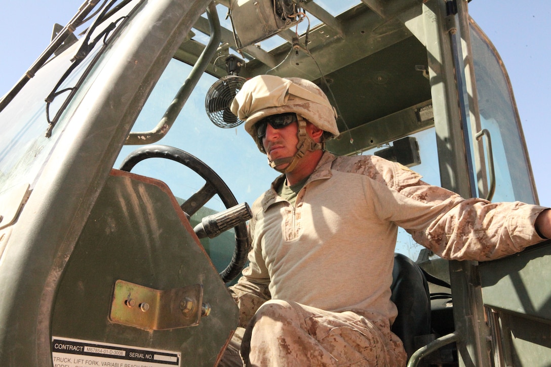 Corporal Christopher E. Gregory closes the door of his Millennia Military Vehicle here, April 11, 2012. The forklift is one of the many pieces of machinery he uses as a heavy equipment operator with Combat Logistics Battalion 4. Gregory, a native of Kimble, Neb., loads heavy cargo and clears areas for construction. (U.S. Marine Corps photo by Lance Cpl. Tyler Reiriz)