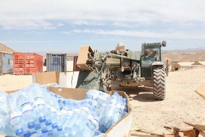 Corporal Christopher E. Gregory, a Kimble, Neb., native and heavy equipment operator with Combat Logistics Battalion 4, extends the arm of his Millennia Military Vehicle to lift a crate of water here, April 12, 2012. The water was loaded onto a convoy to be delivered to Marines at positions across Kajaki. (U.S. Marine Corps photo by Lance Cpl. Tyler Reiriz)