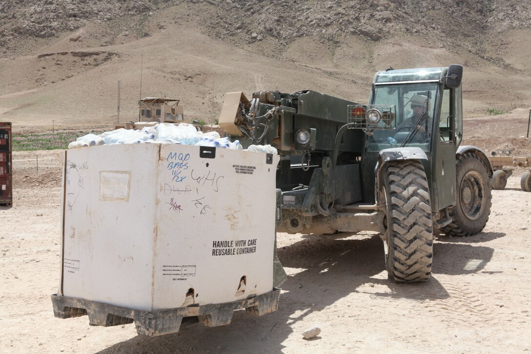 Corporal Christopher E. Gregory, a native of Kimble, Neb., and heavy equipment operator with Combat Logistics Battalion 4, uses a Millennia Military Vehicle to help load water bottles to be delivered to Marines at positions across Kajaki, April 12, 2012. Gregory uses a variety of heavy equipment to move loads too large for Marines to carry by hand. (U.S. Marine Corps photo by Lance Cpl. Tyler Reiriz)