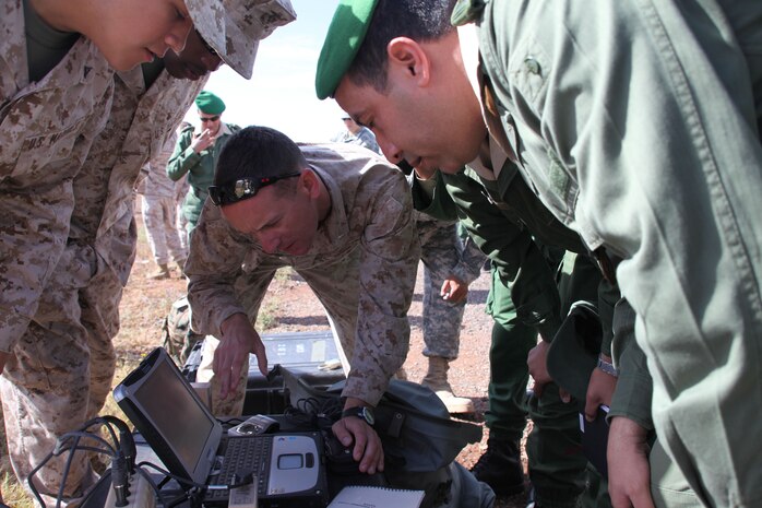 1st Lt. Ben Baker, an assistant intelligence officer for the 24th Marine Expeditionary Unit, observes the live-video feed from an RQ-11B Raven Unmanned Aerial System with members of the Royal Moroccan Armed Forces in support of Exercise African Lion here, April 12, 2012. African Lion is a bi-lateral training exercise between U.S. forces, including the 24th MEU, and Royal Moroccan Armed Forces to promote partnership and mutual understanding between each nation's militaries. The 24th MEU, along with the Iwo Jima Amphibious Ready Group, is currently deployed as a theater security and crisis response force capable of a variety of mission from full-scale combat to humanitarian assistance and disaster relief.