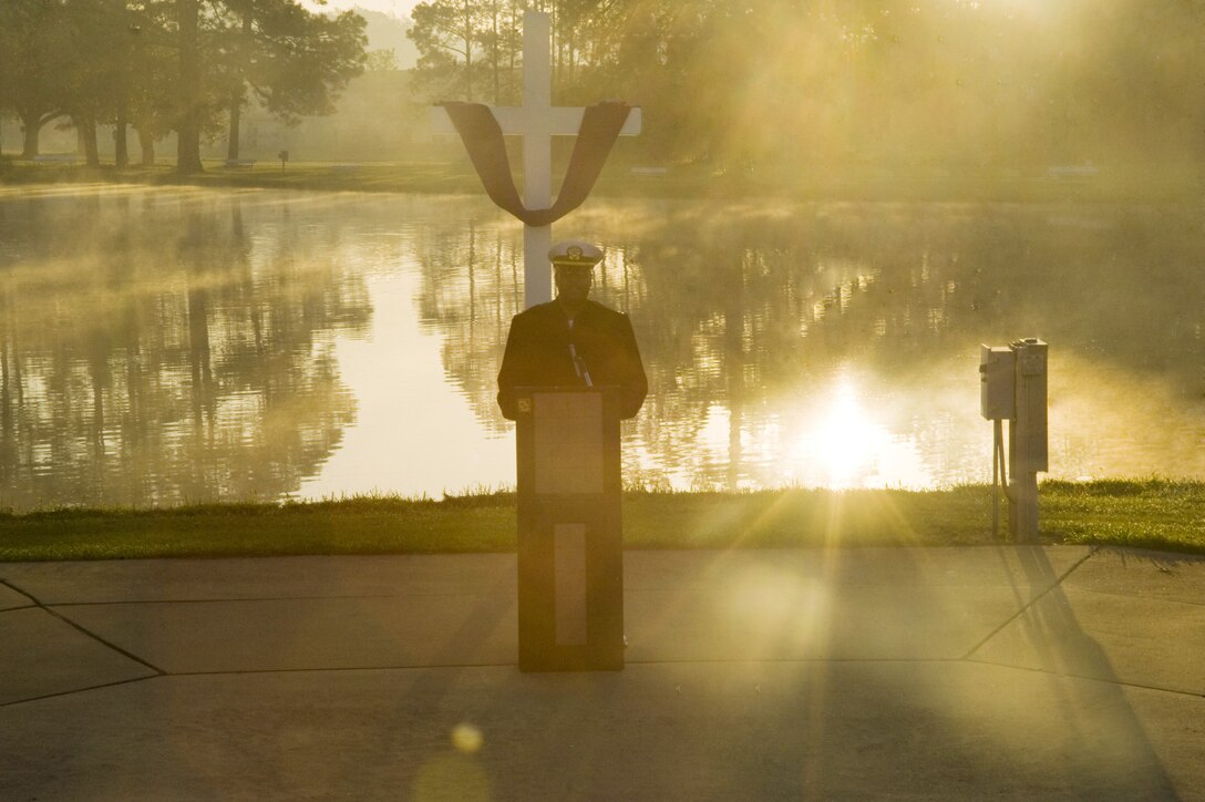 Navy Lt. Kenneth Miller, base chaplain, Marine Corps Logistics Base Albany, delivers an Easter sunrise message as the sun rises over Covella Pond Sunday morning.