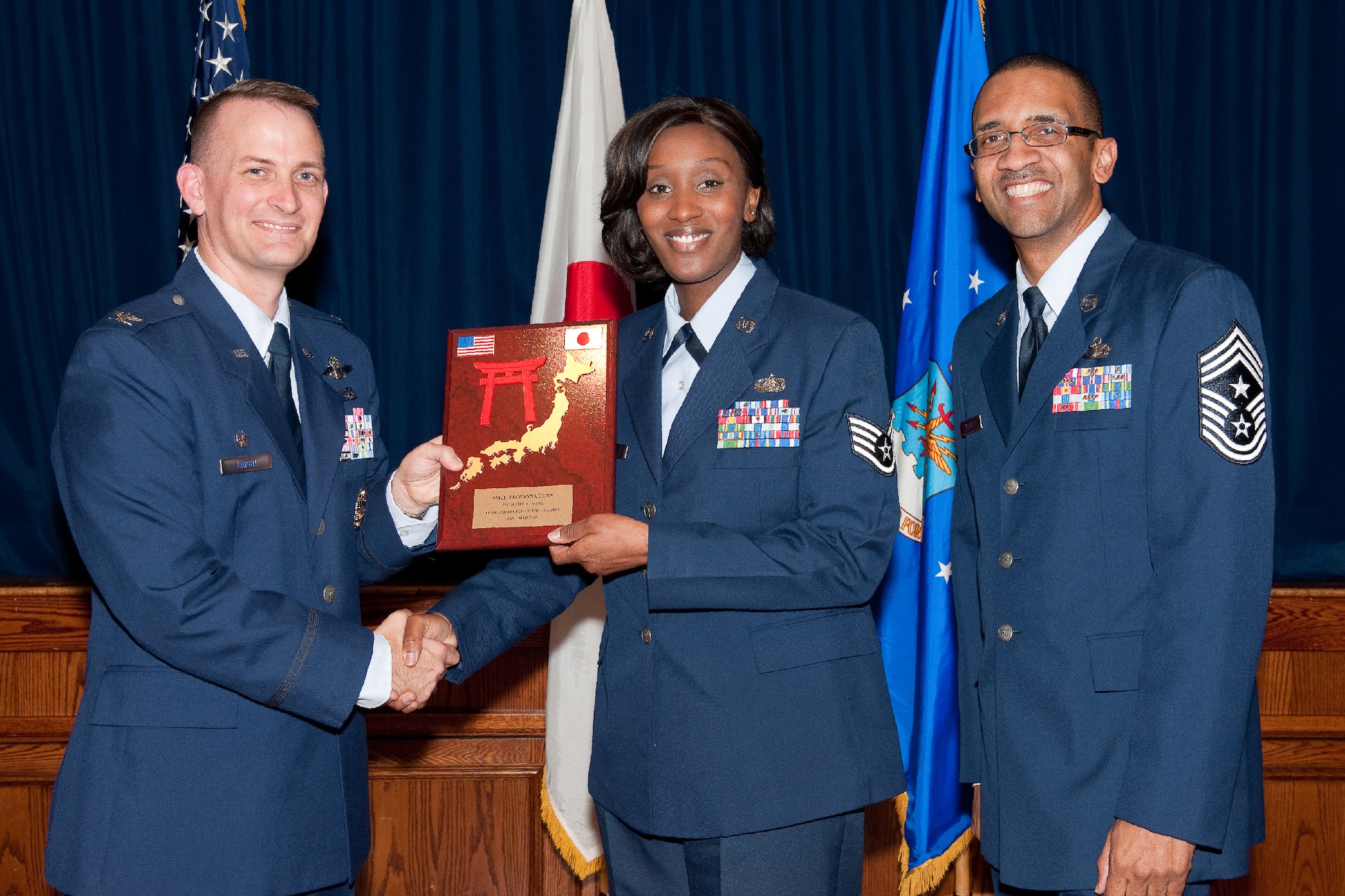 YOKOTA AIR BASE, Japan -- Staff Sgt. Tiawanna Dunn, 374th Communications Squadron, receives the NCO of the Quarter plaque during Team Yokota's First Quarterly Awards ceremony at Yokota Air Base, Japan, April 12, 2012. Col. Bill Knight, 374th Airlift Wing commander, and Command Chief Master Sgt. Ronald Draper, 374th AW, present the award to Dunn during the ceremony. (U.S. Air Force photo/Osakabe Yasuo)