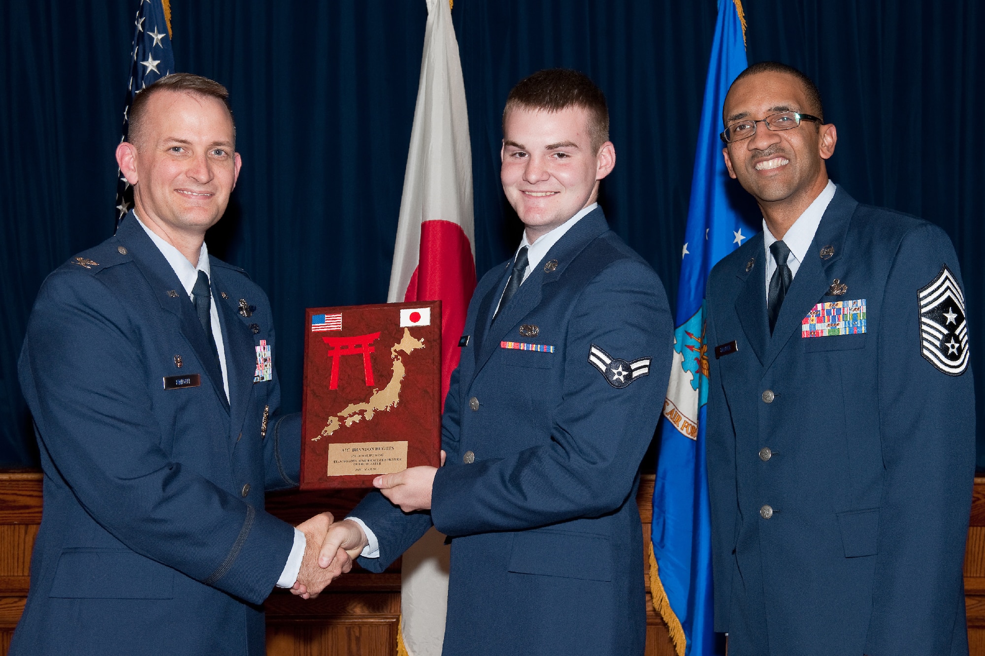 YOKOTA AIR BASE, Japan -- Airman 1st Class Brandon Hughes, 374th Aircraft Maintenance Squadron, receives the Airman of the Quarter plaque during Team Yokota's First Quarterly Awards ceremony at Yokota Air Base, Japan, April 12, 2012. Col. Bill Knight, 374th Airlift Wing commander, and Command Chief Master Sgt. Ronald Draper, 374th AW, present the award to Hughes during the ceremony. (U.S. Air Force photo/Osakabe Yasuo)