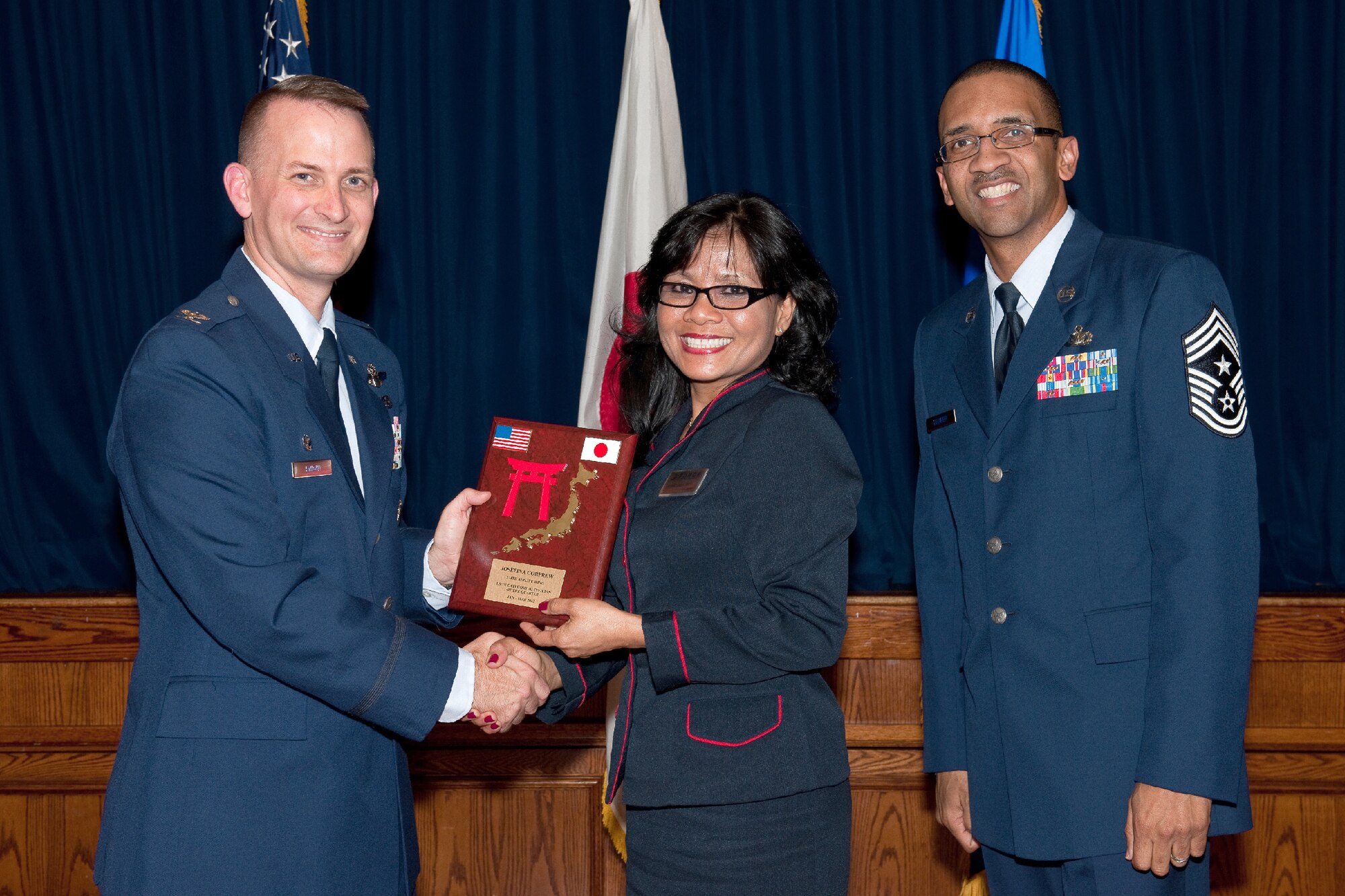 YOKOTA AIR BASE, Japan -- Josefina Corprew, 374th Force Support Squadron, receives the US/JN category III civilian of the Quarter plaque during Team Yokota's First Quarterly Awards ceremony at Yokota Air Base, Japan, April 12, 2012. Col. Bill Knight, 374th Airlift Wing commander, and Command Chief Master Sgt. Ronald Draper, 374th AW, present the award to Corprew during the ceremony. (U.S. Air Force photo/Osakabe Yasuo)