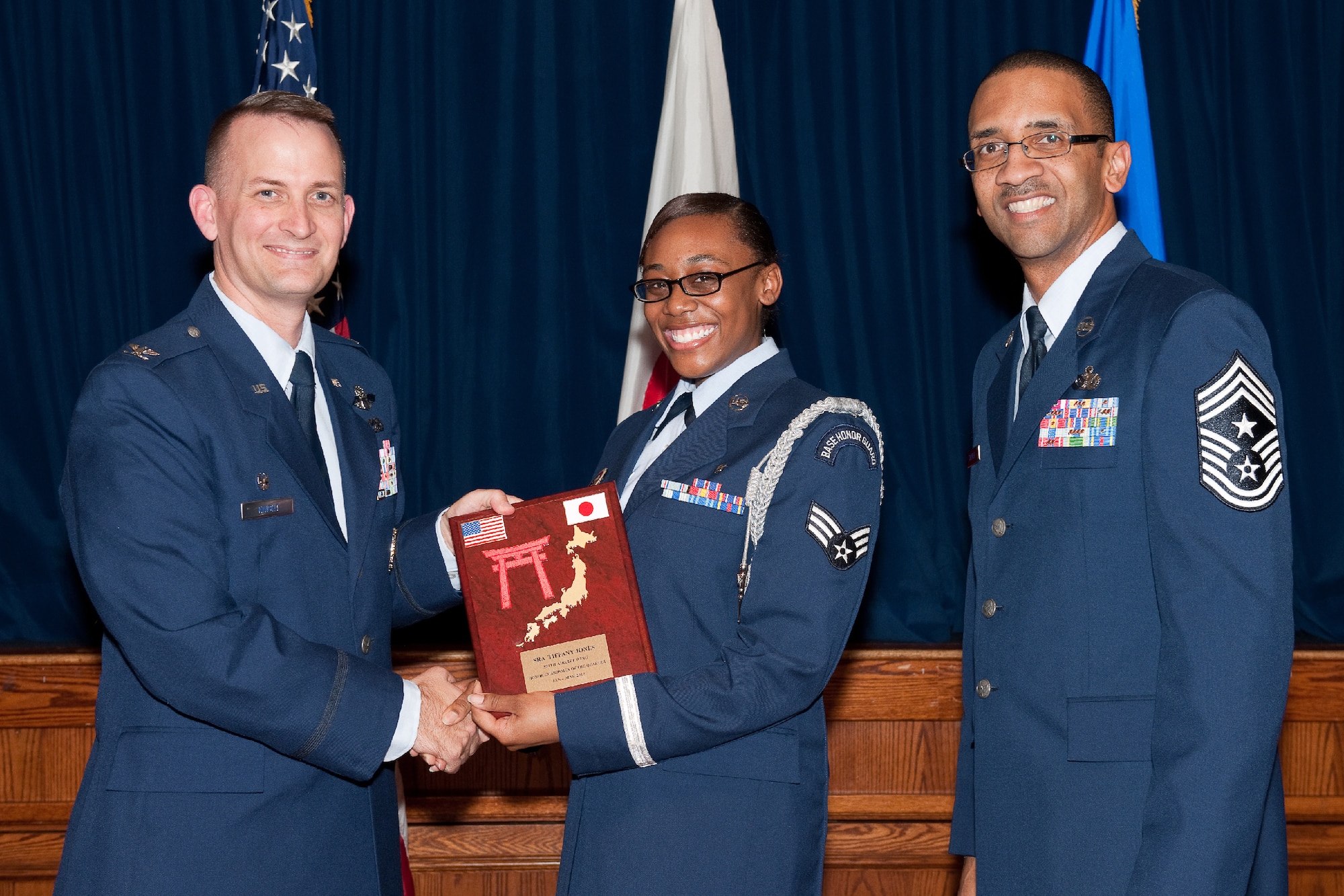 YOKOTA AIR BASE, Japan -- Senior Airman Tiffany Jones, 374th Surgical Operations Squadron, receives the Honor Guardsman of the Quarter plaque during Team Yokota's First Quarterly Awards ceremony at Yokota Air Base, Japan, April 12, 2012. Col. Bill Knight, 374th Airlift Wing commander, and Command Chief Master Sgt. Ronald Draper, 374th AW, present the award to Jones during the ceremony. (U.S. Air Force photo/Osakabe Yasuo)