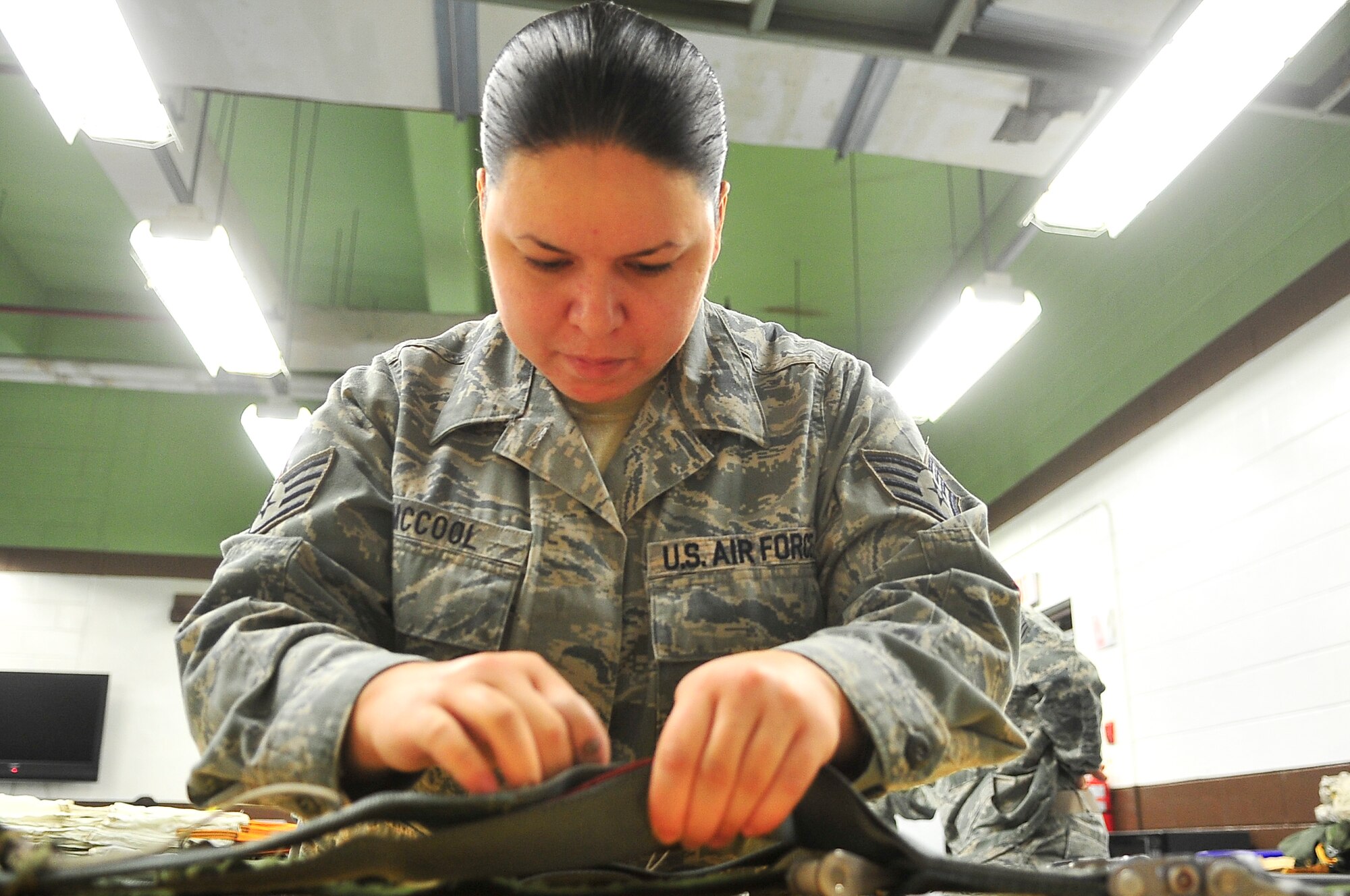 Staff Sgt. Melissa McCool, 51st Operations Support Squadron aircrew flight equipment journeyman, marks a half-inch point on a parachute April 10, 2012. The half-inch point signifies where McCool needs to sew string to generate slack needed in the parachute. (U.S. Air Force photo/Senior Airman Adam Grant)   

