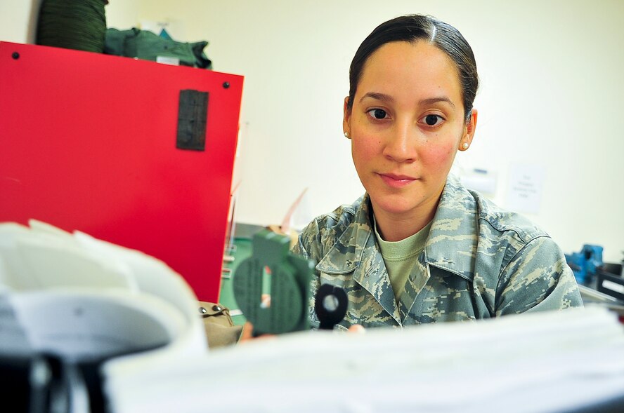 Senior Airman Jennifer Lopez, 51st Operations Support Squadron aircrew flight equipment journeyman, checks the serviceability of a compass April 10, 2012. Lopez ensures the compass is in working order and can be placed in survival gear. (U.S. Air Force photo/Senior Airman Adam Grant)