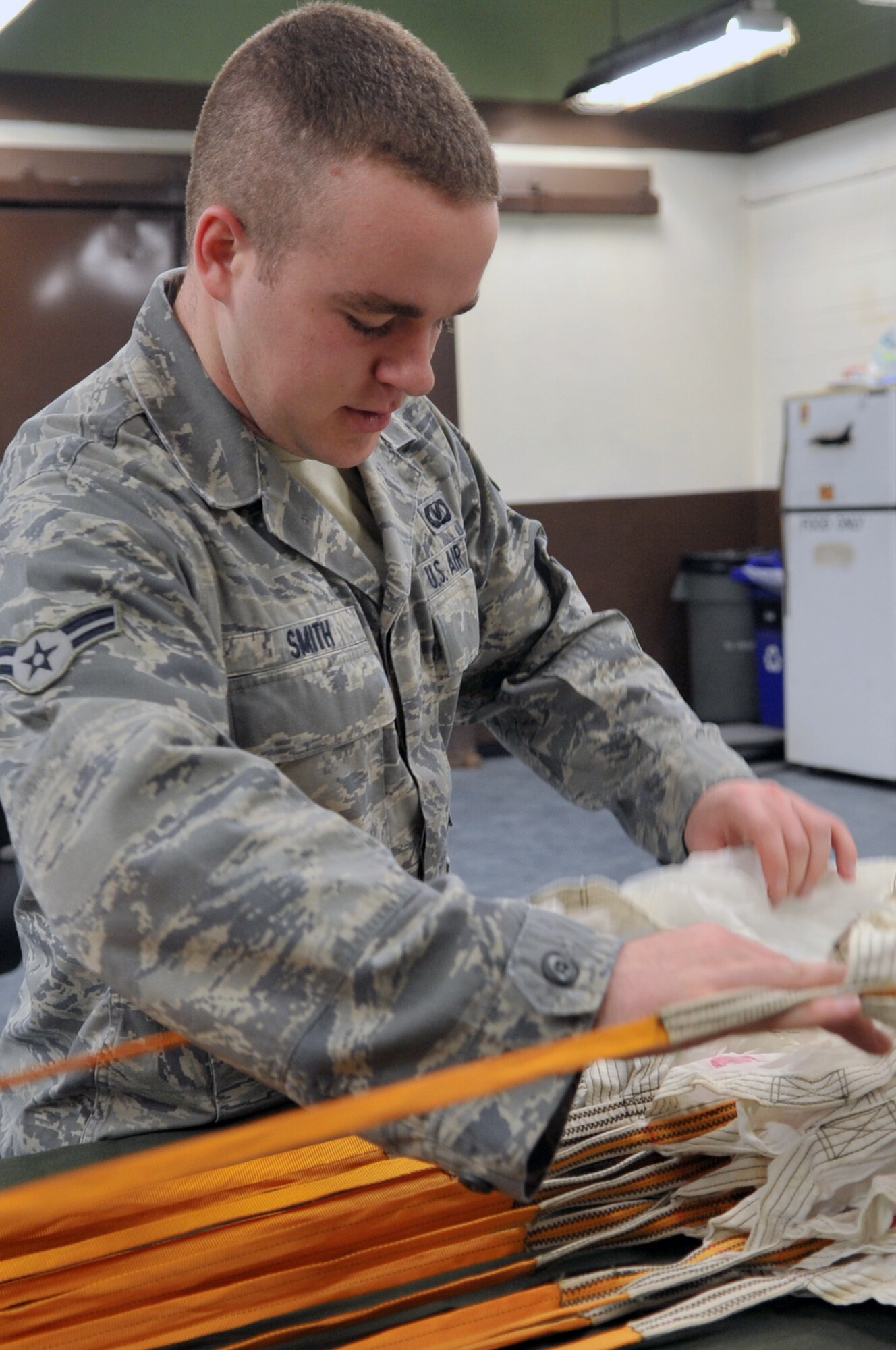 Airman 1st Class Taylor Smith, 51st Operations Support Squadron aircrew flight equipment journeyman, inspects the canopy of a parachute here April 10, 2012. After unpacking the chute, Smith completes a canopy inspection to ensure there is no damage. (U.S. Air Force photo/Staff Sgt. Craig Cisek)