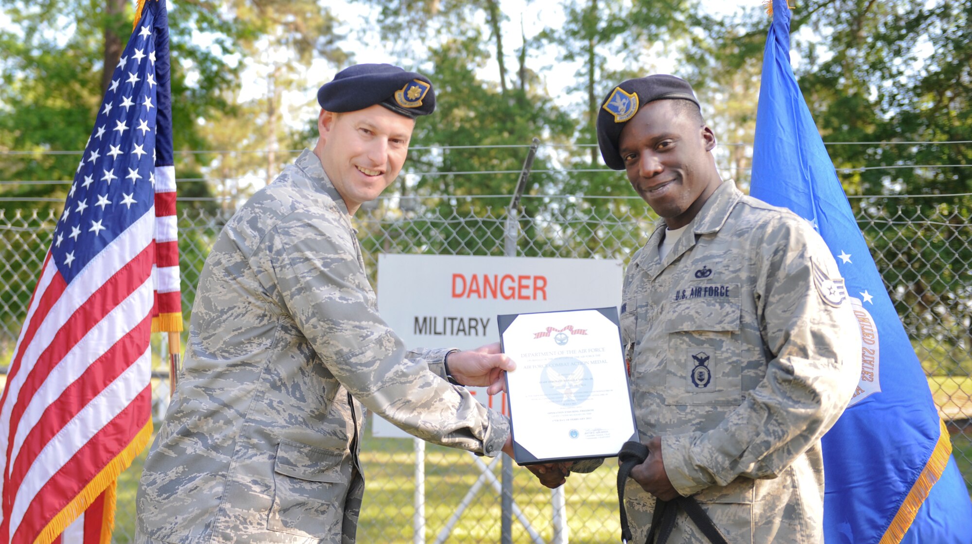 U.S. Air Force Maj. Justin Secrest, 23d Security Forces Squadron commander, presents the Combat Action Medal to Staff Sgt. Ronald Young, 23d Security Forces Squadron military working dog handler, at Moody Air Force Base, Ga., April 12, 2012. Young has been a MWD handler for three years. (U.S. Air Force photo by Airman 1st Class Douglas Ellis/Released)
