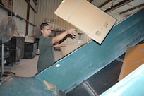 Gerard Gutierrez, Joint Base San Antonio-Randolph Recycling Center technician, bales cardboard April 10 at the recycling center. Cardboard recycling brings large profits for the base. (U.S. Air Force photo by Airman 1st Class Alexis Siekert)