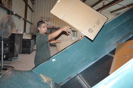 Gerard Gutierrez, Joint Base San Antonio-Randolph Recycling Center technician, bales cardboard April 10 at the recycling center. Cardboard recycling brings large profits for the base. (U.S. Air Force photo by Airman 1st Class Alexis Siekert)