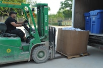 Rene Hernandez, Joint Base San Antonio-Randolph Recycling Center technician, transports recycled paper to be baled April 10 at the center. Once the recycling bins are emptied, the cardboard boxes are placed next to each other to be processed. (U.S. Air Force photo by Airman 1st Class Alexis Siekert)