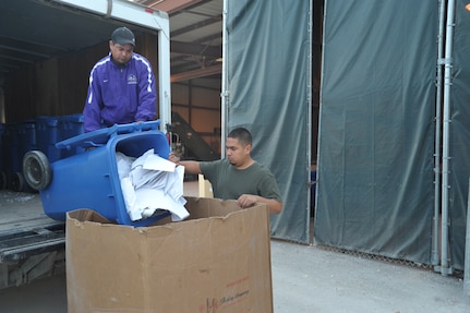 Gerardo Gutierrez (right) and Tony Lara, Joint Base San Antonio-Randolph Recycling Center technicians, empty recycle bins filled with paper into a cardboard box to be baled for pickup April 10. The center collects recyclables from all of Randolph Monday-Friday, 7 a.m.-4 p.m. (U.S. Air Force photo by Airman 1st Class Alexis Siekert) 