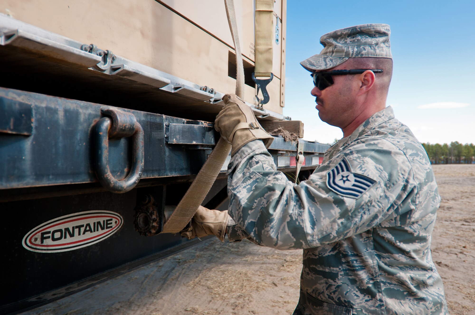 Tech. Sgt. Jeremy Hitt, a vehicle operator from the 22nd Logistics Readiness Squadron at McConnell Air Force Base, Kan., straps cargo to a flatbed trailer March 29, 2012, at Joint Base McGuire-Dix-Lakehurst, N.J. Hitt was working at the Forward Node of a Joint Task Force-Port Opening during Eagle Flag, a U.S. Air Force-sponsored exercise to prepare units for operating in deployed environments. The Kentucky Air National Guard's 123rd Contingency Response Group operated the airlift side of the JTF-PO, known as an Aerial Port of Debarkation. (U.S. Air Force photo by Maj. Dale Greer)